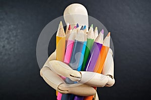 Wooden mannequin and color pencils