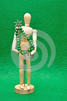 A wooden mannequin display with a christmas tree made out of wire and beads