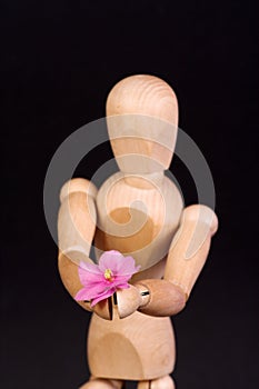 A wooden mannequin with flower