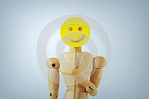 Wooden mannequin with happy face paddle - Concept of happiness, fun and positive feedback