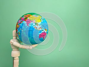 Wooden mannequin holding earth globe