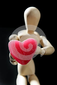 Wooden mannequin holding a red jelly heart shape