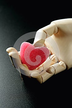 Wooden mannequin holding a red jelly heart shape