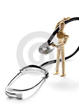 Wooden mannequin holding a stethoscope