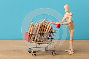 Wooden mannequin with miniature shopping cart