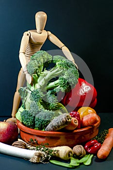 Wooden mannequin and a mix of vegetables and fruits