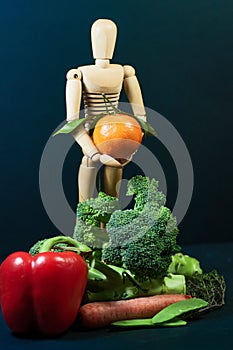 Wooden mannequin and a mix of vegetables and fruits