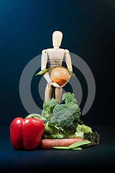 Wooden mannequin and a mix of vegetables and fruits