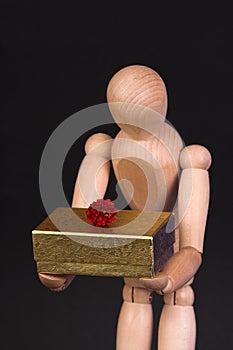 A wooden mannequin with present