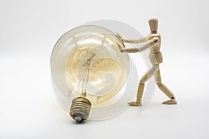 Wooden mannequin pushing a electric light bulb photo