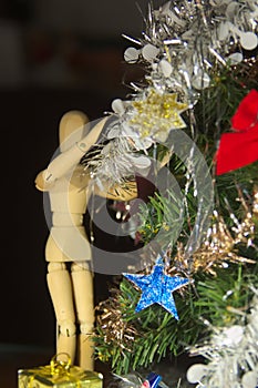 A wooden mannequin riding a Christmas tree