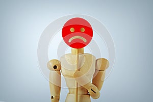 Wooden mannequin with sad face paddle - Concept of sadness, dissatisfaction and negative feedback