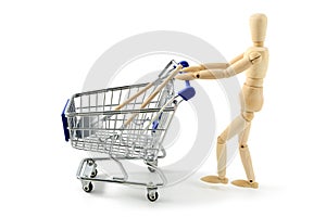 wooden mannequin shopping garden tools with a cart on white isolated background