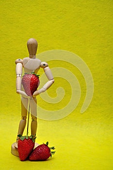 A wooden mannequin with strawberries