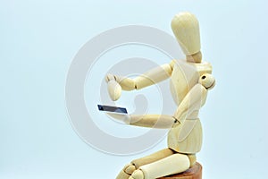 Wooden mannequin with a mobile in hand photo