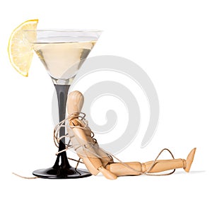 Wooden mannikin strapped to the glass of vermouth. Concept of drunkenness, alcohol abuse