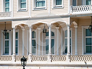 Wooden mansion close up detail. Beautiful classic architecture balcony with arch,  columns and many windows