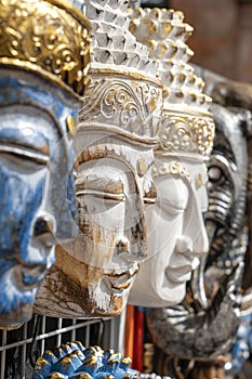 Wooden mask with the image of the Buddha on display for sale on street market in Bali, Indonesia. Handicrafts and souvenir shop