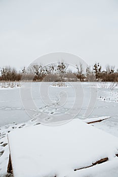 the wooden masonry on the pond is crushed by snow in winter