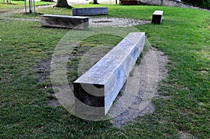 Wooden massive park bench shape block on granite natural cobblestone irregular chipped brown gray pavement, oak wood prism painted