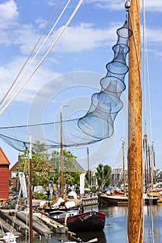 Wooden mast with fishing net in the harbor of Spakenburg