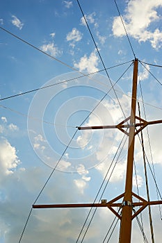 The wooden mast of an old ship on the background of blue sky.Going out to sea and adventures