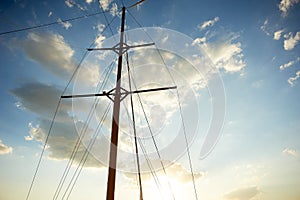 The wooden mast of an old ship on the background of blue sky.Going out to sea and adventures