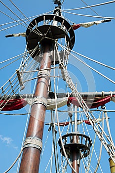 Wooden mast of the ship with rope-ladder and photo