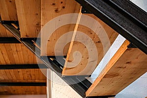 Wooden and metal stairs in a log house, detail