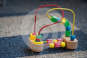 Wooden and metal toy for toddlers with small geometric objects on wires