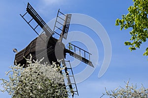 Wooden Mill on blue sky background. Old Windmill at dawn. Windmill farm. Rural landscape village on the hill in Trzew