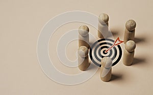 wooden miniature figure team encompass to dartboard with arrow for setup business objective target and goal concept