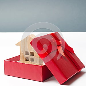 Wooden miniature house in a gift box. Housing as a gift. Win an apartment in the lottery. To inherit property. Holiday discounts. photo