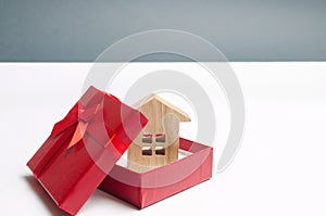 Wooden miniature house in a gift box. Housing as a gift. Win an apartment in the lottery. To inherit property. Holiday discounts. photo