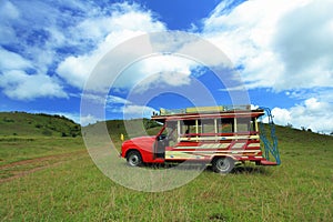 Wooden minibus in green grass mountain at ranong province
