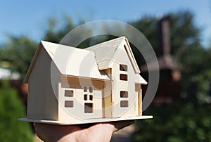 Wooden model of house in hands