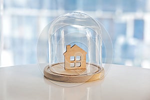 Wooden model of house under glass cap