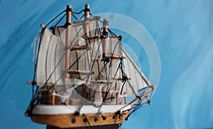 Wooden model of a three-masted sailboat on a blue