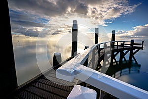 Wooden mooring jetty in seaport with a view over the Dutch Wadden Sea