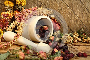 Wooden mortar, dog rose and dried flowers