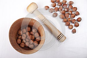 Wooden mortar with nuts on white table