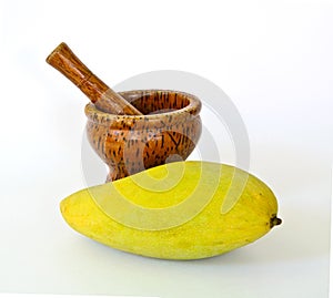 Wooden mortar and pestle with yellow mango