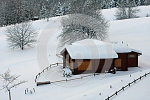 Wooden mountain chalet in the Alps in Italy after a heavy snowfall photo