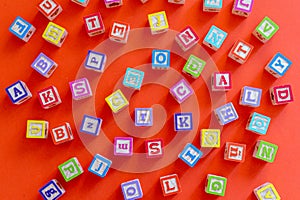 Wooden multicolored blocks with letters on orange background. Education for preschooler, reading, alphabet. Back to school concept