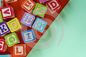 Wooden multicolored blocks with letters on orange background. Education for preschooler, reading, alphabet. Back to school concept