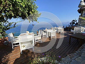 Wooden natural seats and desk with sea view.