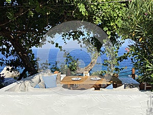 Wooden natural seats and desk with sea view.