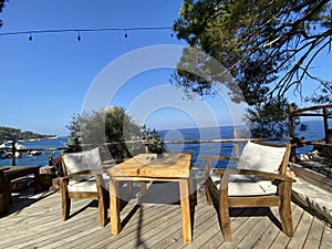 Wooden natural seats and desk with sea view.