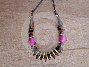 Wooden necklace with brown background. The necklace on the wooden background.