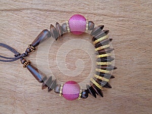 Wooden necklace with brown background. The necklace on the wooden background.
